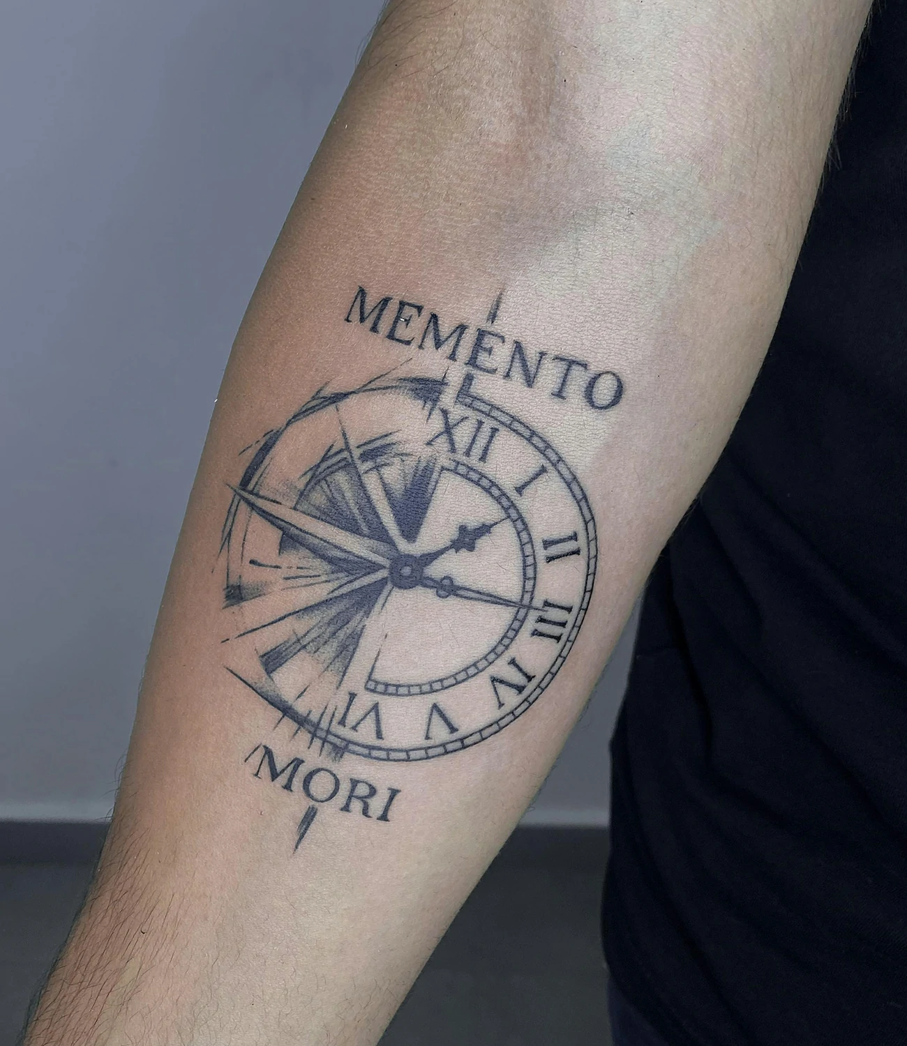 memento mori clock tattoo: A clock or watch tattoo paired with "memento mori," symbolizing the passage of time and life's impermanence.