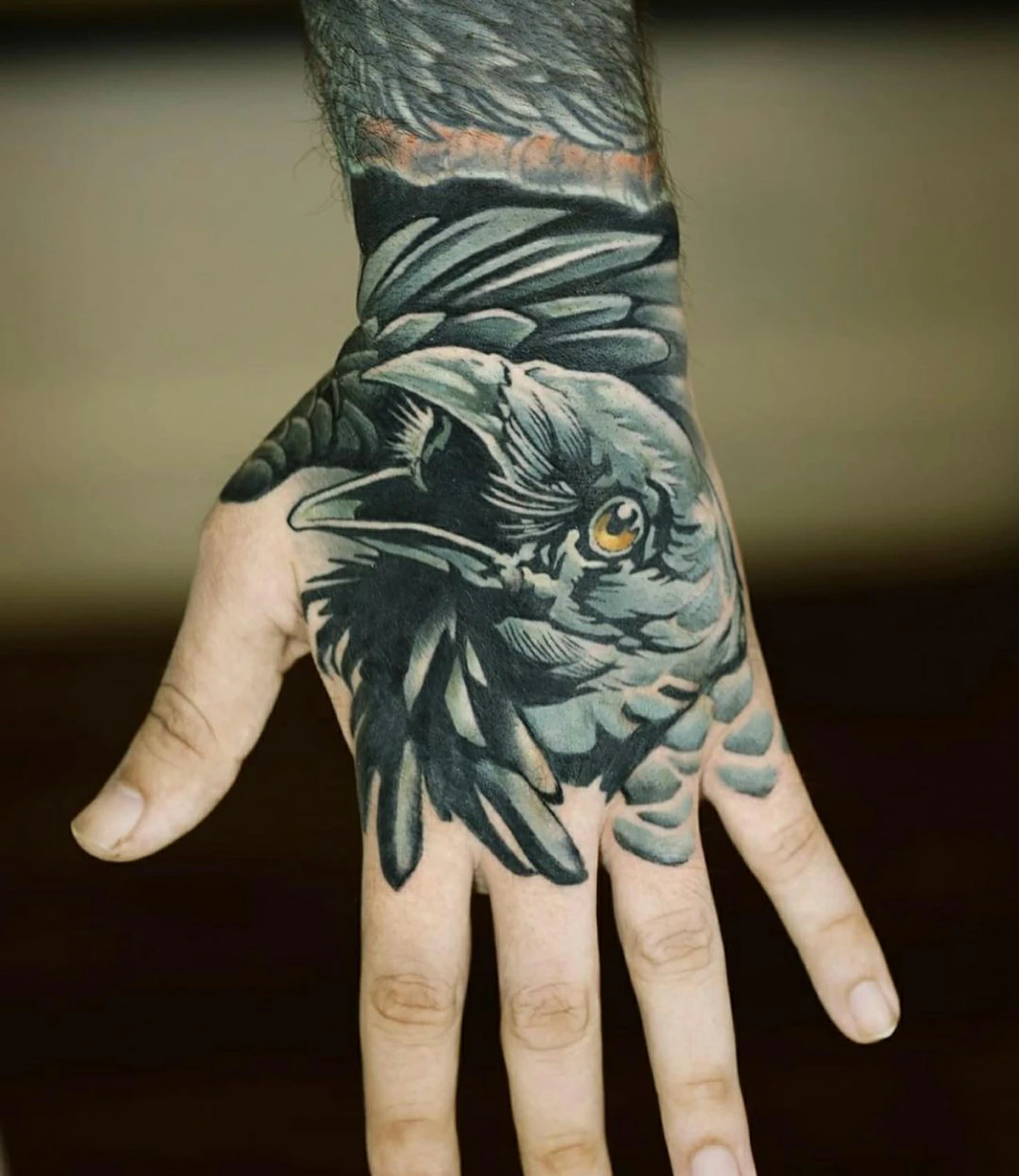 Raven hand tattoo: A bold choice, placing a raven tattoo on the hand.