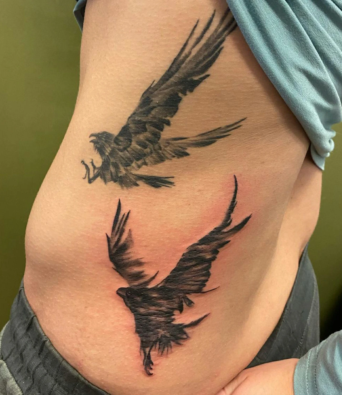Flying raven tattoo: A dynamic tattoo showing a raven in flight.