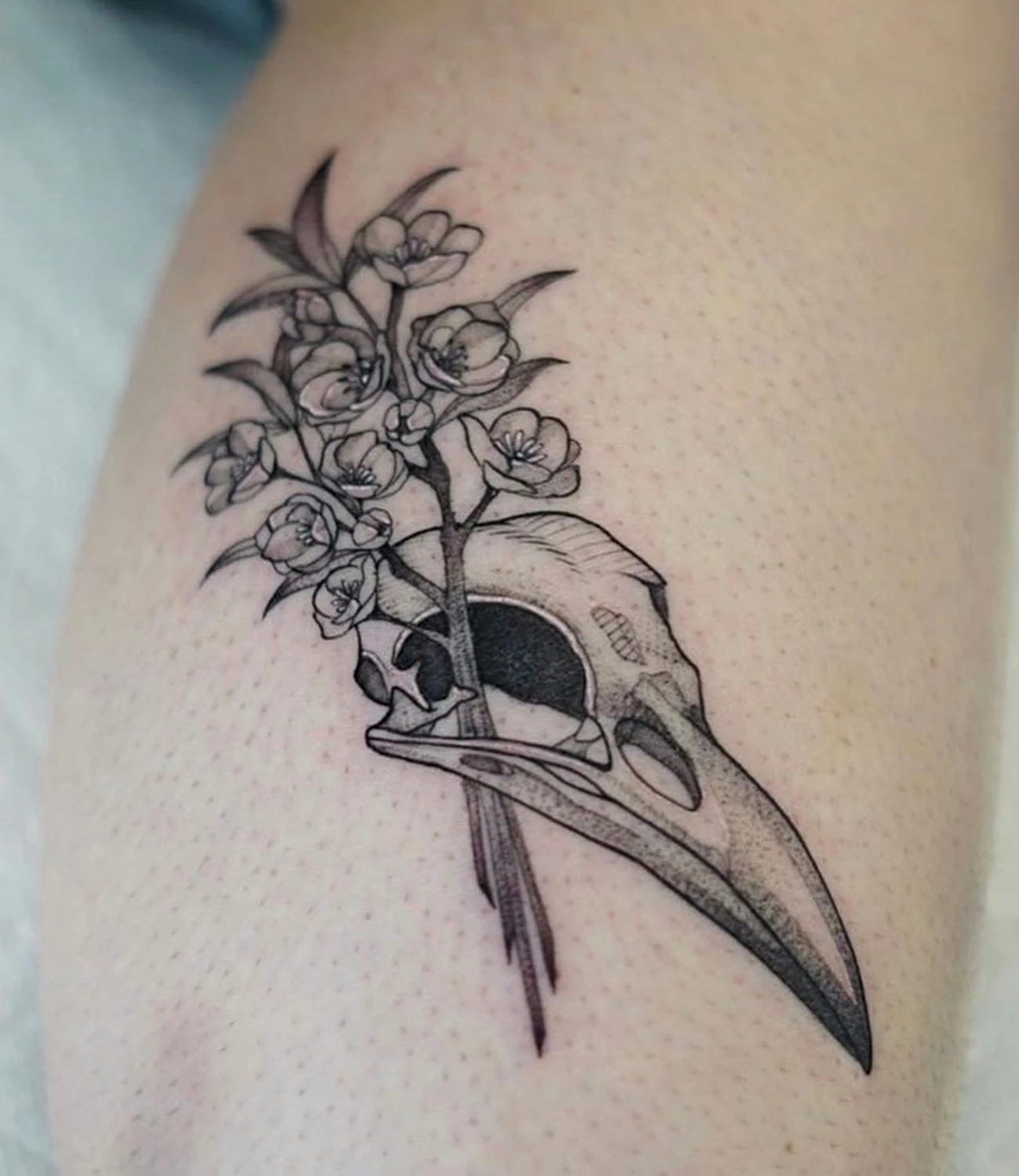 Raven skull tattoo: A striking tattoo combining a raven and a skull for a dramatic effect.