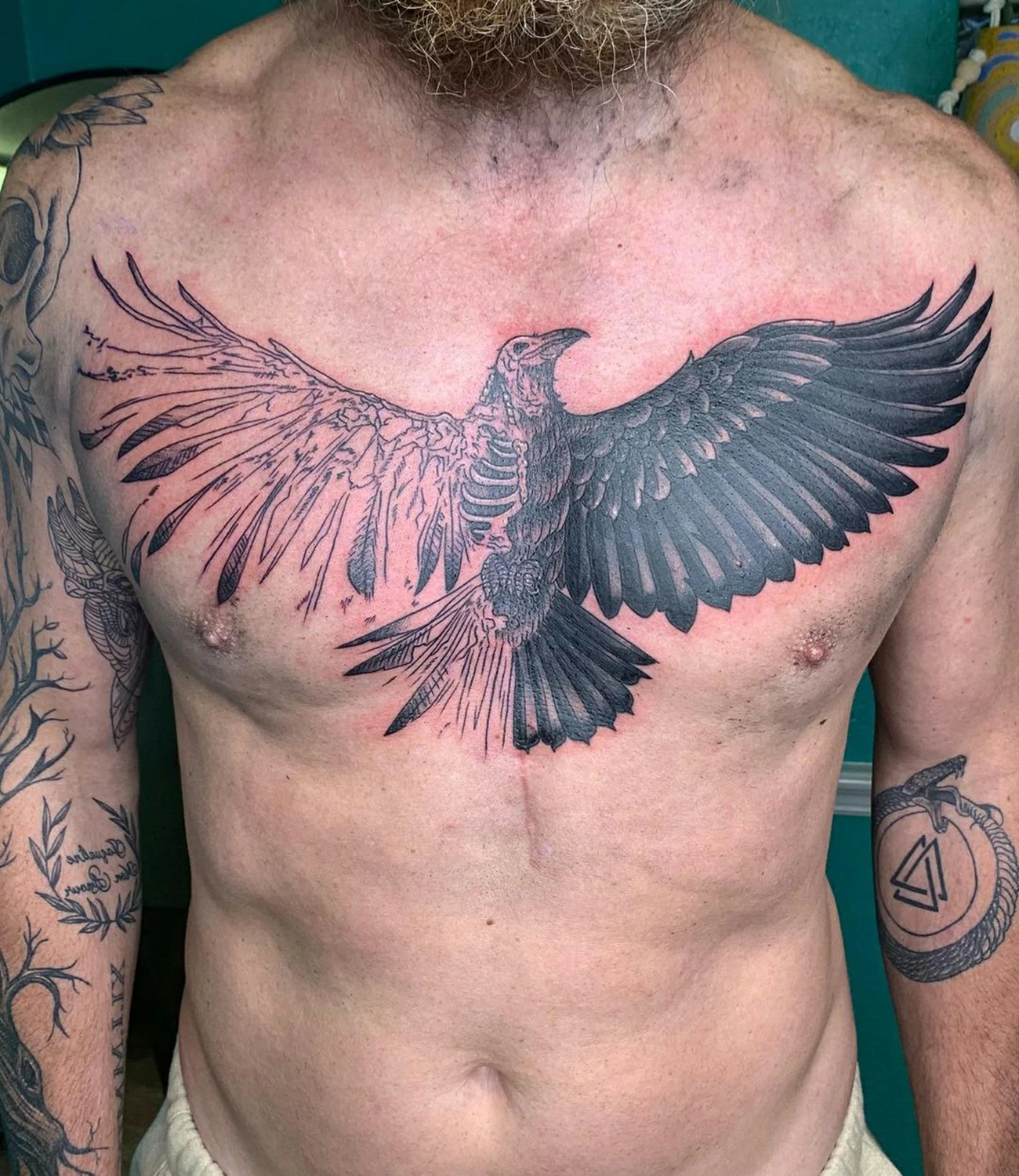 Raven chest tattoo: A large, detailed raven tattoo designed to cover the chest area.